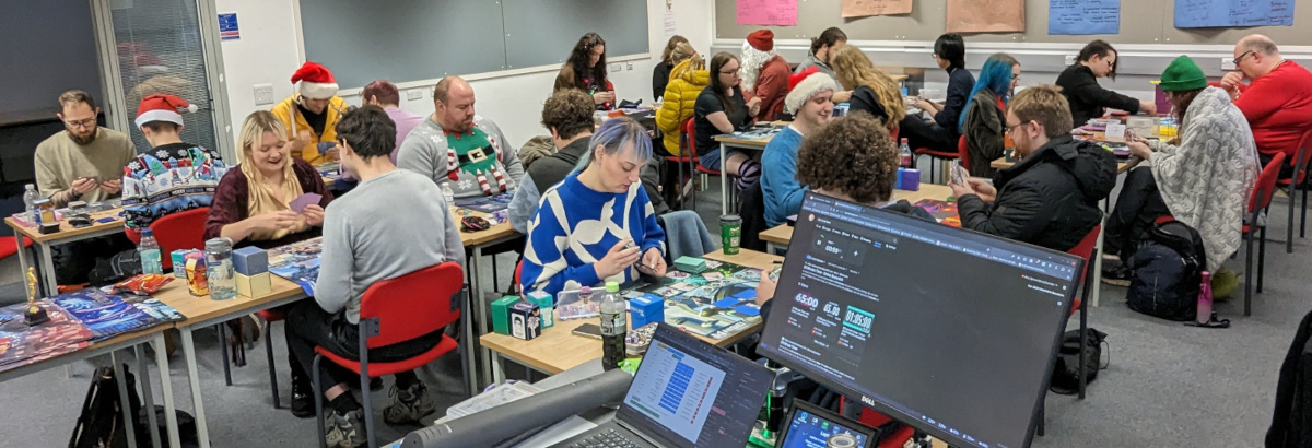 A classroom full of Netrunner players, some in costume. You can see Anarch Santa hiding near the back!