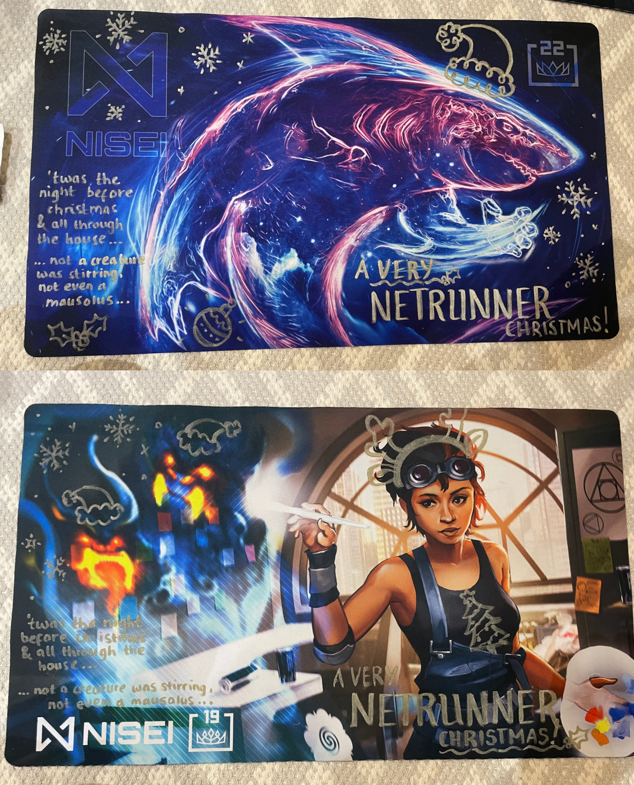 The playmats - one Hakarl 1.0 with a Santa hat, and a The Artist with reindeer antlers.